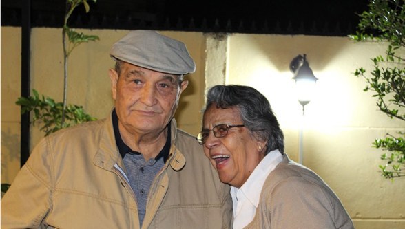 Pareja de adultos mayores sonriendo en su hogar